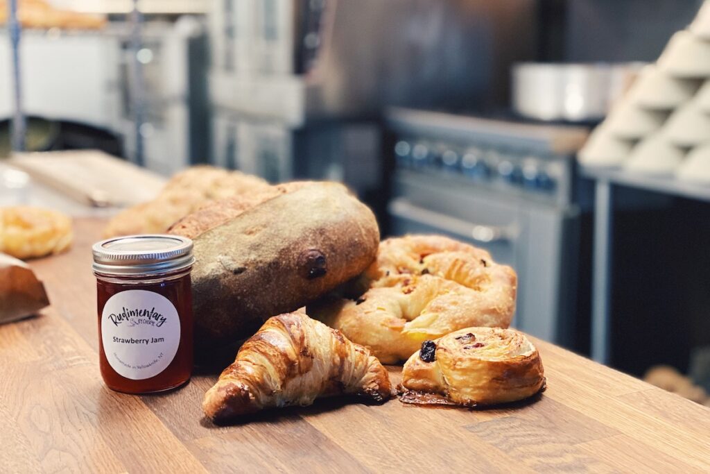 Sourdough, croissants and a jar of jam on a counter