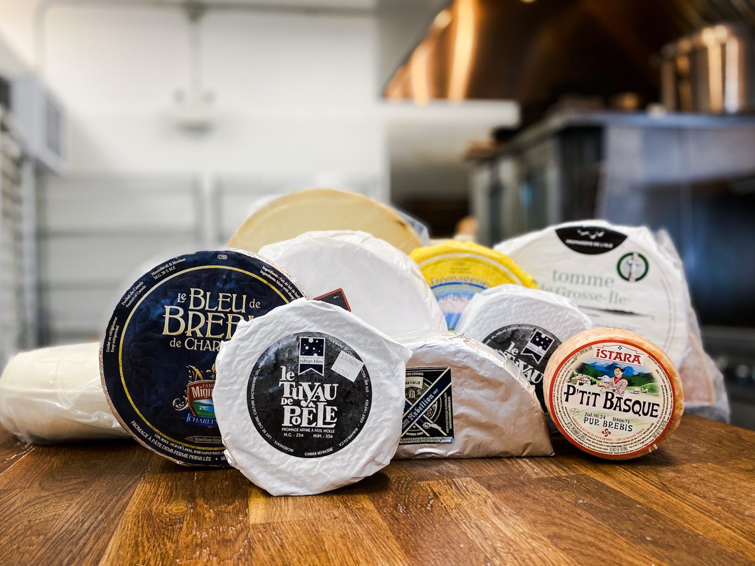 Canadian and European cheeses on a wooden counter