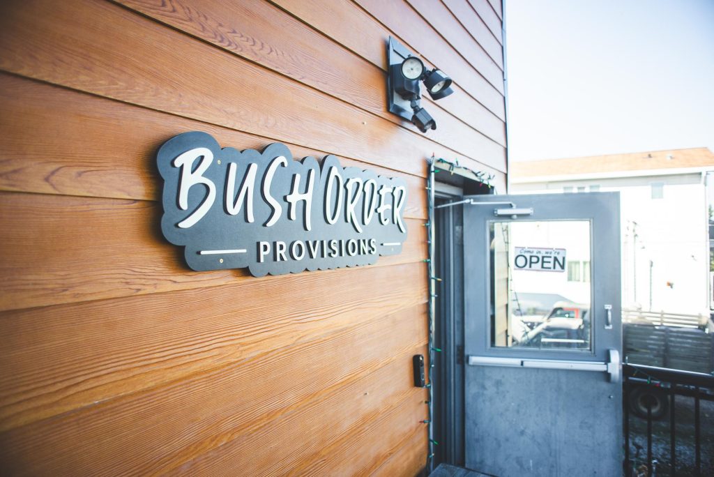 The Bush Order Provisions storefront sign beside an open door