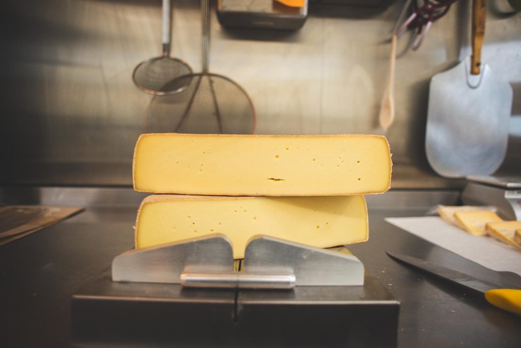 A wheel of aged cheese being cut