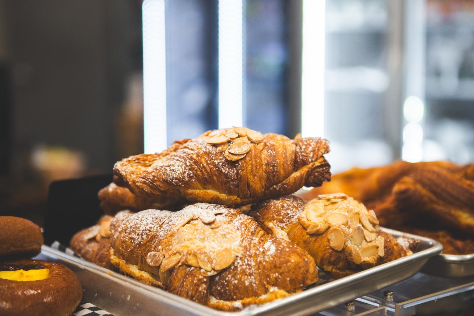 A tray of twice-baked almond croissants dusted with icing sugar